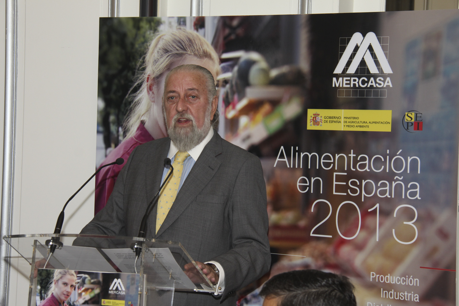 Foto de hombre hablando en atril por la presentación de Alimentación en España en 2013