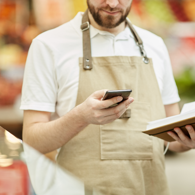 Trabajador en mercado consultando información en su smartphone