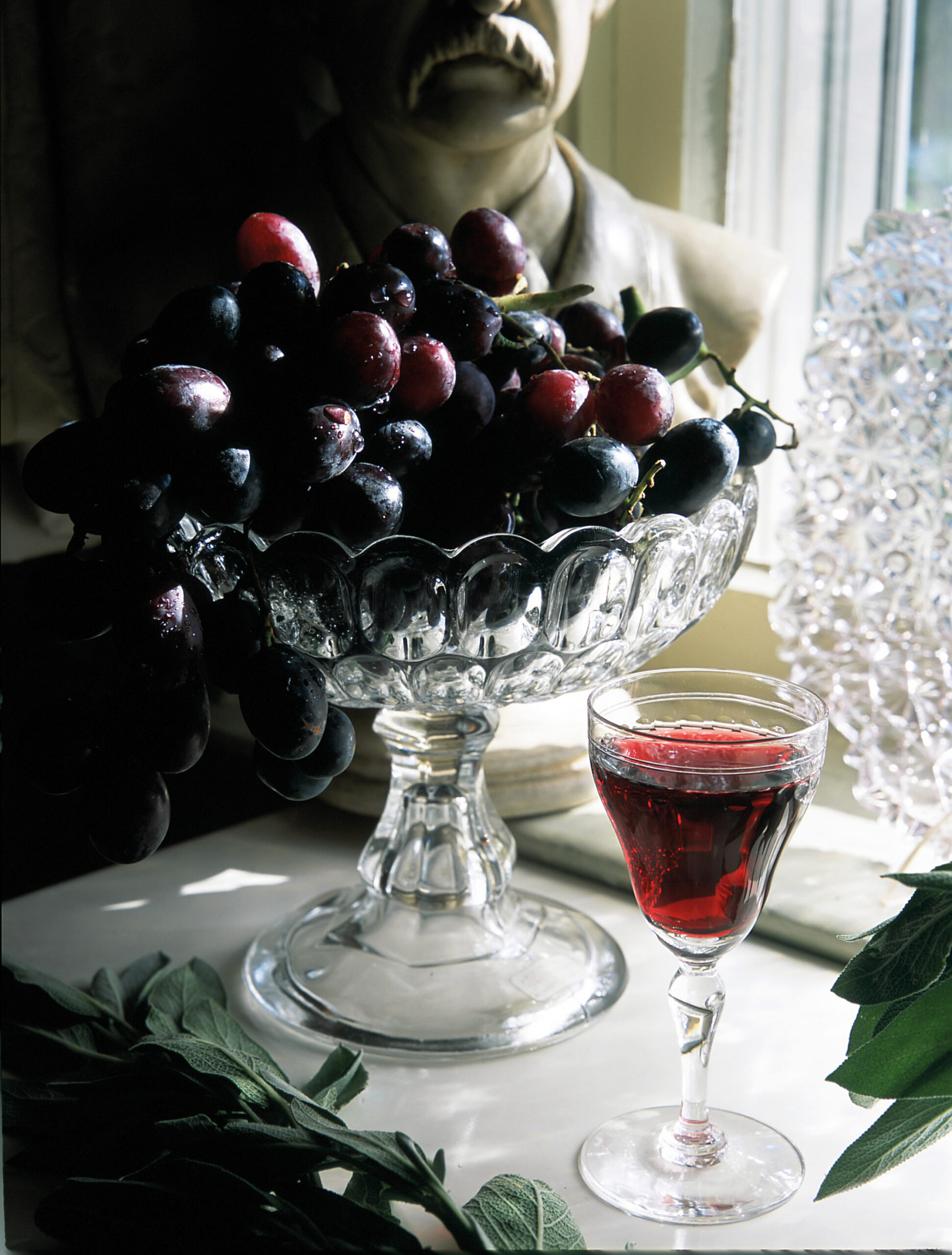 uvas en un jarrón y una copa de vino